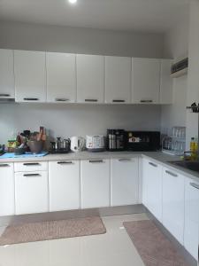 素叻88house suratthani的白色的厨房配有白色橱柜和电器