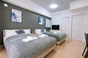 大阪Dotonbori Royal II的一间卧室配有两张床和一台平面电视