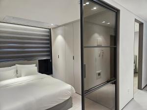 首尔HOTEL THE DESIGNERS LYJ SUITE YEOKSAM的一间卧室设有一张床和一个滑动玻璃门