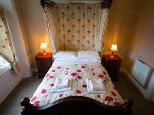 彭里斯The Station Hotel Penrith的一间卧室,床上有红色的鲜花