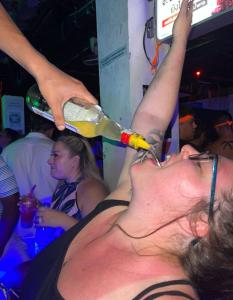 皮皮岛Blanco Beach Bar Hostel的男人从瓶子里喝一杯