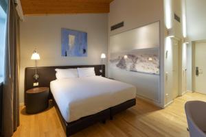斯坎迪亚诺波易阿多酒店的卧室配有一张白色大床
