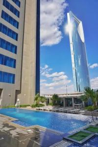 利雅德DAMAC Riyadh - Luxury Apartments的一座高楼旁的带游泳池的酒店