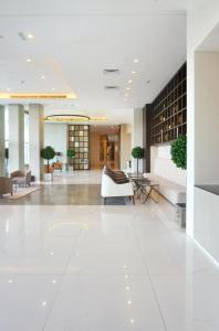 利雅德DAMAC Riyadh - Luxury Apartments的白色的大大堂设有白色的沙发和桌子