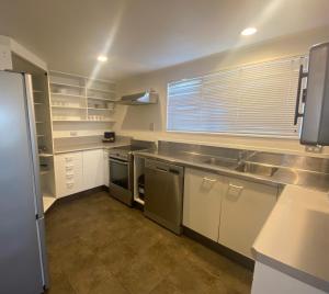 陶波Lakeside Taupo Motel的厨房配有白色橱柜和不锈钢用具