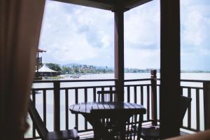 珍南海滩兰卡威波浪别墅度假村的阳台配有桌椅,享有水景。