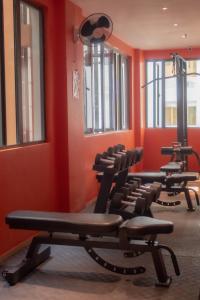 安吉利斯瓦伦蒂诺斯酒店的一间健身房,里面设有几把椅子,房间拥有橙色的墙壁