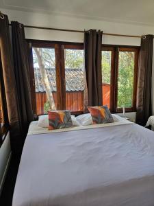沙美岛Horizon Resort的卧室配有一张白色大床和两个窗户