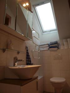 温蒂加斯顿费伦沃宏舍贝尔酒店的一间带水槽和卫生间的浴室以及窗户。