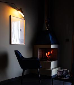 比亚恩卡维拉PODERE DELL'ETNA SEGRETA - Essential Nature Hotel的黑暗的客房配有椅子和壁炉