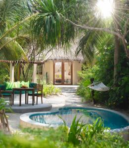 特尔罕都岛可可棕榈杜尼鲁的一个带游泳池和桌椅的度假村