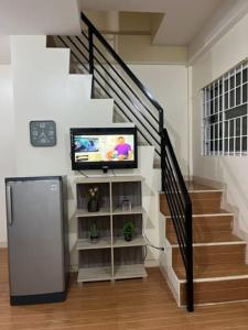 LoculanEstilo 2-Bedroom Apartment B的客厅设有楼梯、电视和楼梯
