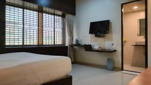 纳威孟买Hotel Sai Nidhi Executive-MindSpace Airoli Navi Mumbai的一间卧室配有一张床和一台平面电视
