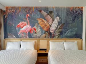 绥和市Mia Apec Mandala Phú Yên的一间卧室配有两张床和火烈鸟壁画