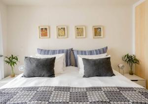 普利登堡湾Plett Holiday Apartment的卧室配有白色床和蓝色及白色枕头