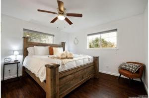 圣安东尼奥Experience Serenity in a 4BR3BA Downtown Home的一间卧室配有一张木床和吊扇