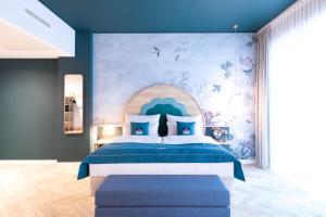 康斯坦茨the niu Flower的一间卧室配有一张蓝色墙壁的床