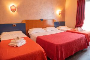 马里纳·迪·瓦尔卡图罗贝拉维斯塔酒店 的两张位于酒店客房的床,配有红色和白色床单