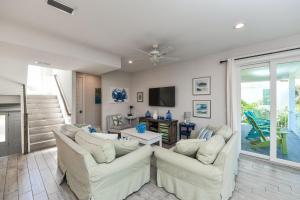 霍姆斯海滩Malibu Beach的客厅配有2张白色沙发和电视