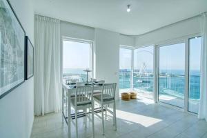 迪拜Stunning 2BR with Sea and Ain Dubai View at JBR的白色的客房配有桌椅和窗户。