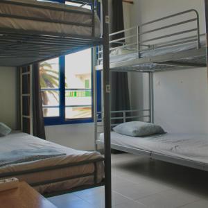法马拉Famara Home stay的带窗户的客房内的两张双层床