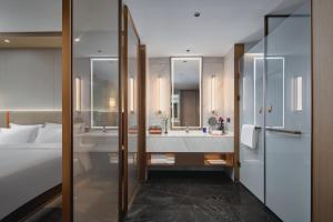 西安西安秦都传奇voco酒店的一间带床、浴缸和水槽的浴室