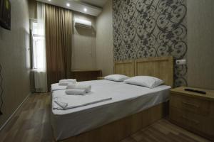 第比利斯Family Hotel Avlabar的一间卧室配有两张床和白色毛巾。