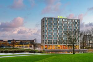 鹿特丹ibis Styles Rotterdam Ahoy的 ⁇ 染酒店大楼的公园