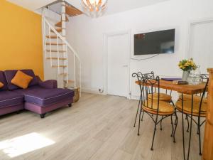 兰迪德诺'Llandudno Central' - 2 Bed Luxury Flat, Close to Town and Beaches的客厅配有紫色沙发和桌子