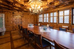 施维茨Wysses Rössli Swiss Quality Hotel的大房间设有一张大木桌和椅子
