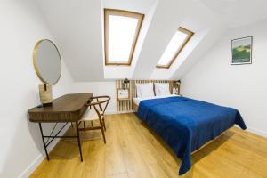 莱斯科Apartamenty Parkowa 9的一间卧室配有一张床、一张书桌和一面镜子