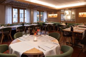 施维茨Wysses Rössli Swiss Quality Hotel的用餐室配有桌椅和酒杯