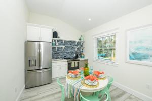 霍姆斯海滩Villa #1 Sailfish的厨房配有桌椅和冰箱。