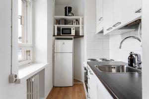 赫尔辛基Nordic Studio near tram & metro 'Kallio' area的白色的厨房配有水槽和冰箱