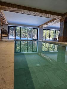 波罗维茨"Park Hotel Ela"的客房设有带玻璃地板和窗户的游泳池。