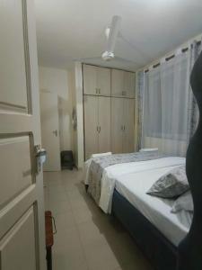 蒙巴萨Joly Apartments, Nyali Mombasa的一间卧室设有一张大床和一个窗户。