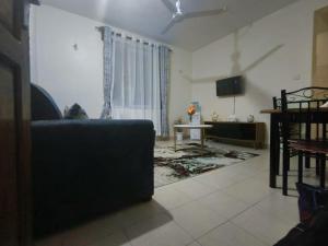 蒙巴萨Joly Apartments, Nyali Mombasa的带沙发和电视的客厅