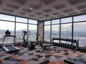 绥和市Apec Mandala Condotel Sea View Comhomes Phú Yên的一个带健身器材的健身房,位于带窗户的建筑内