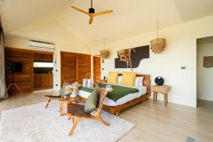 苏梅岛Wild Cottages Elephant Sanctuary Resort的一间卧室设有一张床和一间客厅。