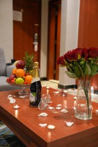 吉达فندق قصر توبال للشقق المخدومة的一张桌子,上面放着一瓶香槟和花瓶