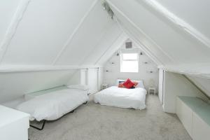 KentSecret Seaside Retreat的阁楼卧室设有两张床和窗户。