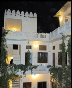 布什格尔Pushkar Guest House的一座白色的建筑,晚上有灯光