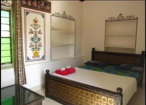 布什格尔Pushkar Guest House的一间卧室配有一张大床和镜子