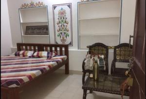布什格尔Pushkar Guest House的一间卧室设有两张床、一张桌子和窗户。