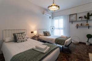 科尔多瓦Ático Puente Romano PARKING GRATUITO的一间卧室设有两张床和窗户。