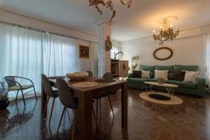 科尔多瓦Ático Puente Romano PARKING GRATUITO的客厅配有桌子和绿色沙发