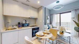 迪拜Primestay - DAMAC Zada 1-Bedroom Residence in Business Bay的厨房以及带桌椅的起居室。