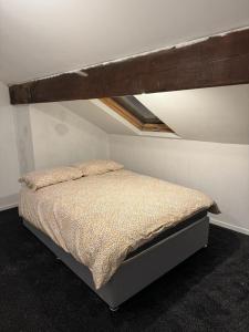 哈德斯菲尔德Victor's House的一间位于屋顶的房间的卧室,配有一张床