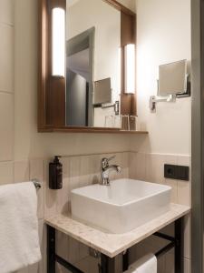 哈尔姆斯塔德Elite Hotel Mårtenson的浴室设有白色水槽和镜子