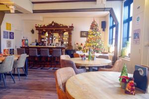 斯欣奥普赫尔Bed & Breakfast Hotel Het Gerendal的餐厅的圣诞树,配有桌椅